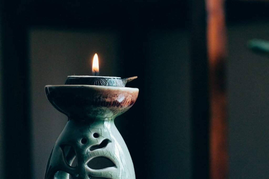 A single candle flame glowing in a dark setting