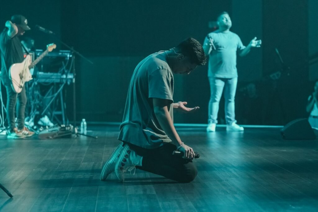 Christians kneeling or standing in church during embodied prayer and worship