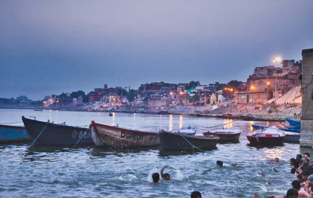 A distant view of a cremation ghat on the Ganga in Varanasi, representing Hindu cremation practice without sensationalizing mourners