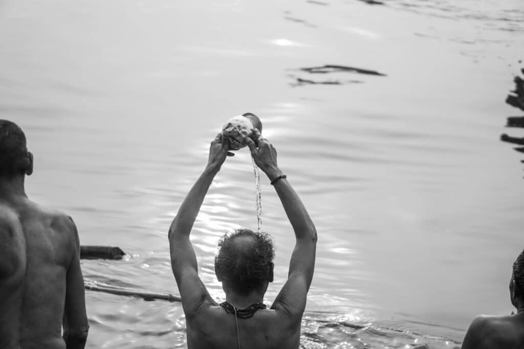 People gathered along a riverbank for ritual and communal activity