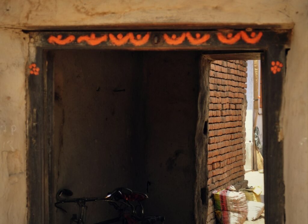 A traditional Indian doorway decorated with a toran of leaves or flowers